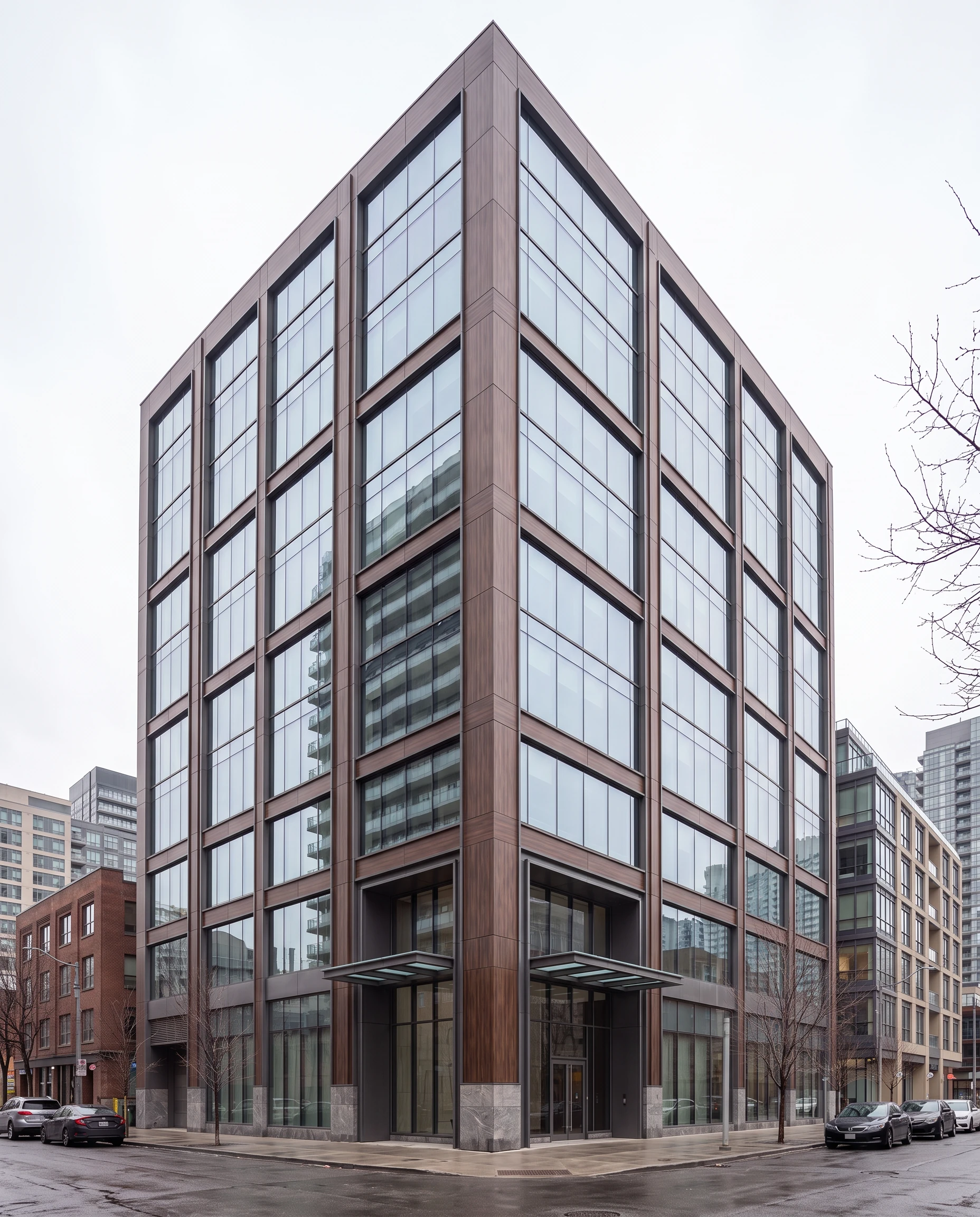 Contemporary urban office building with wood-toned cladding, expansive glazing, and a prominent corner entrance